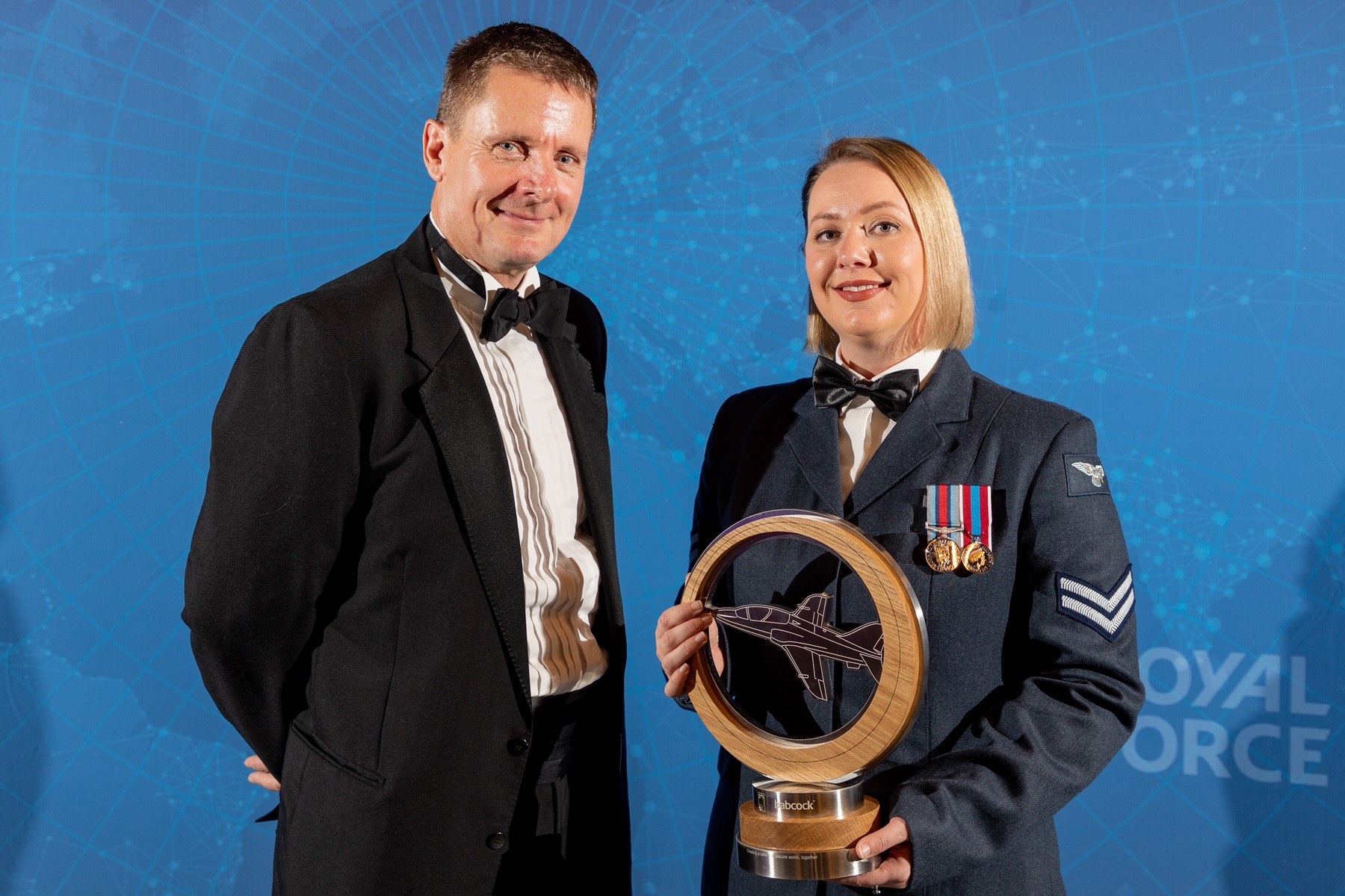Image shows RAF personnel with circular award.